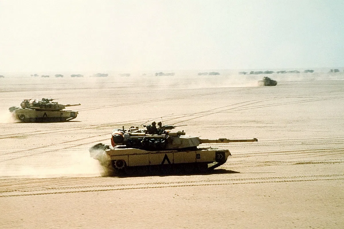 3rd आर्मर्ड डिवीजन के M1A1 अब्राम्स मुख्य युद्धक टैंक 15 फरवरी 1991 को ऑपरेशन डेजर्ट स्टॉर्म के दौरान एक मिशन पर निकलते हैं। पृष्ठभूमि में एक M2/M3 ब्रैडली देखा जा सकता है। (फोटोग्राफर के मेट चीफ पेटी ऑफिसर डीडब्ल्यू होम्स II, यूएस नेवी द्वारा लिया गया)
